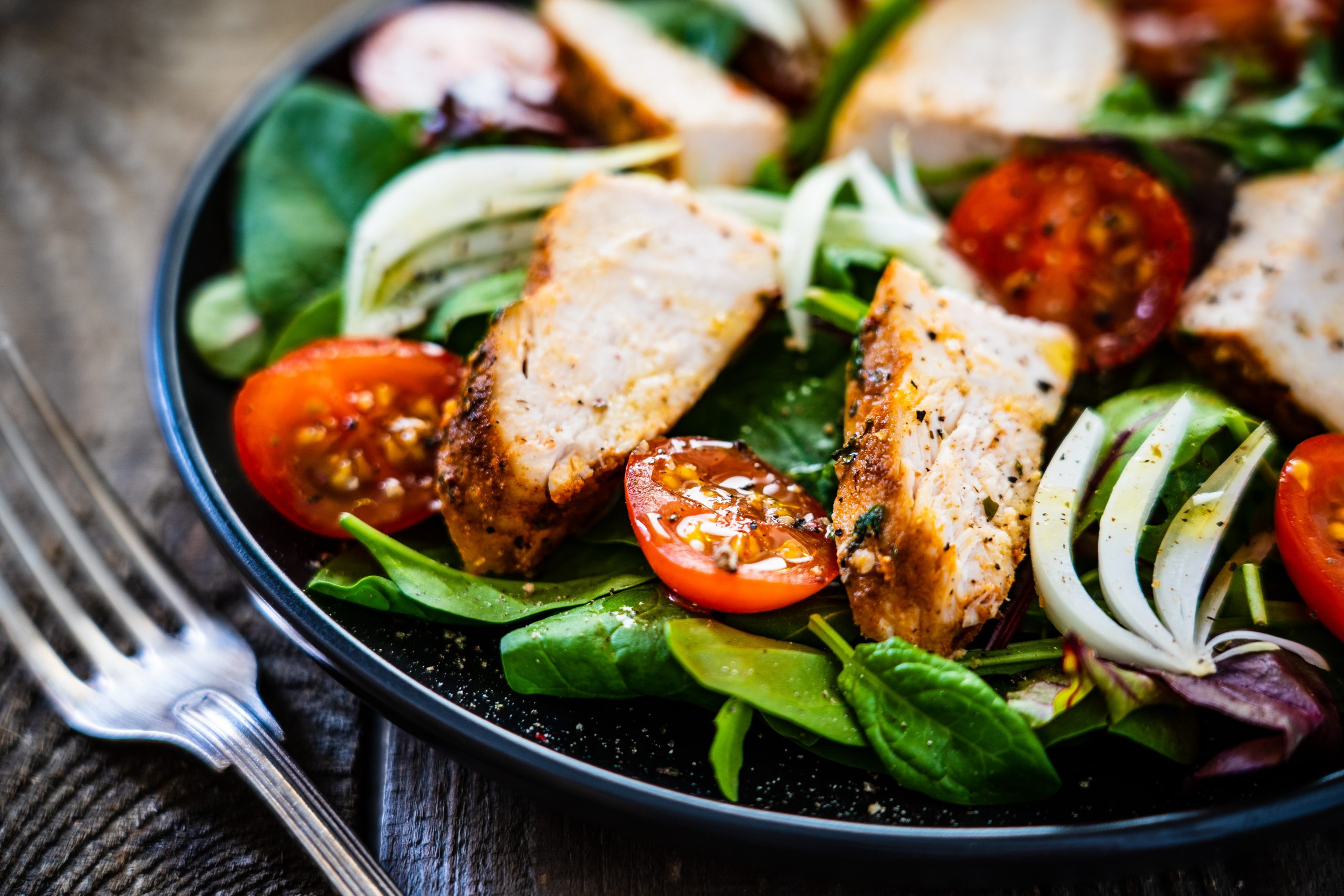 Caesar salad - barbecue chicken breast and vegetables on wooden Sandwichs
